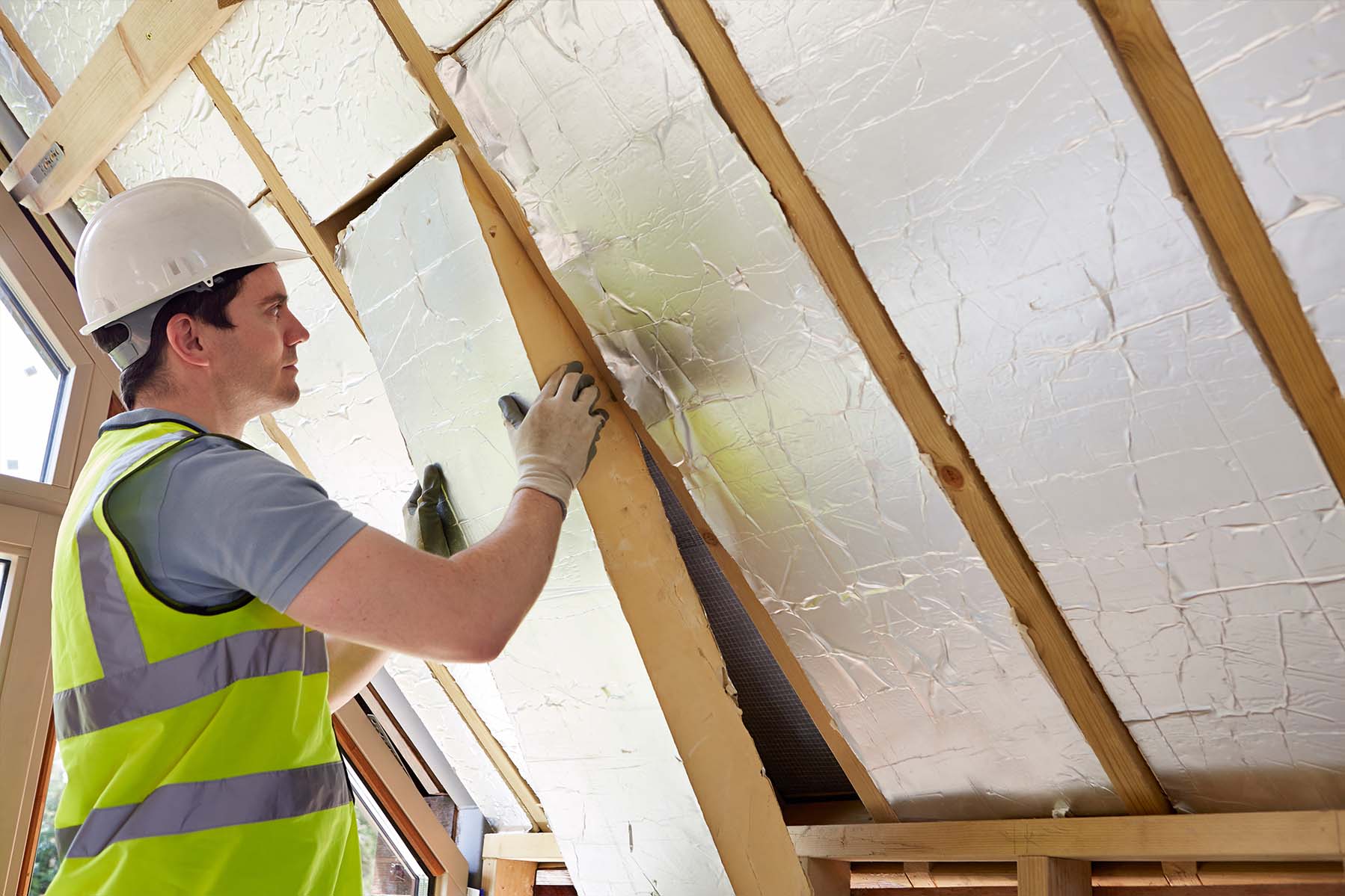 Technician installing roof insulation Ireland